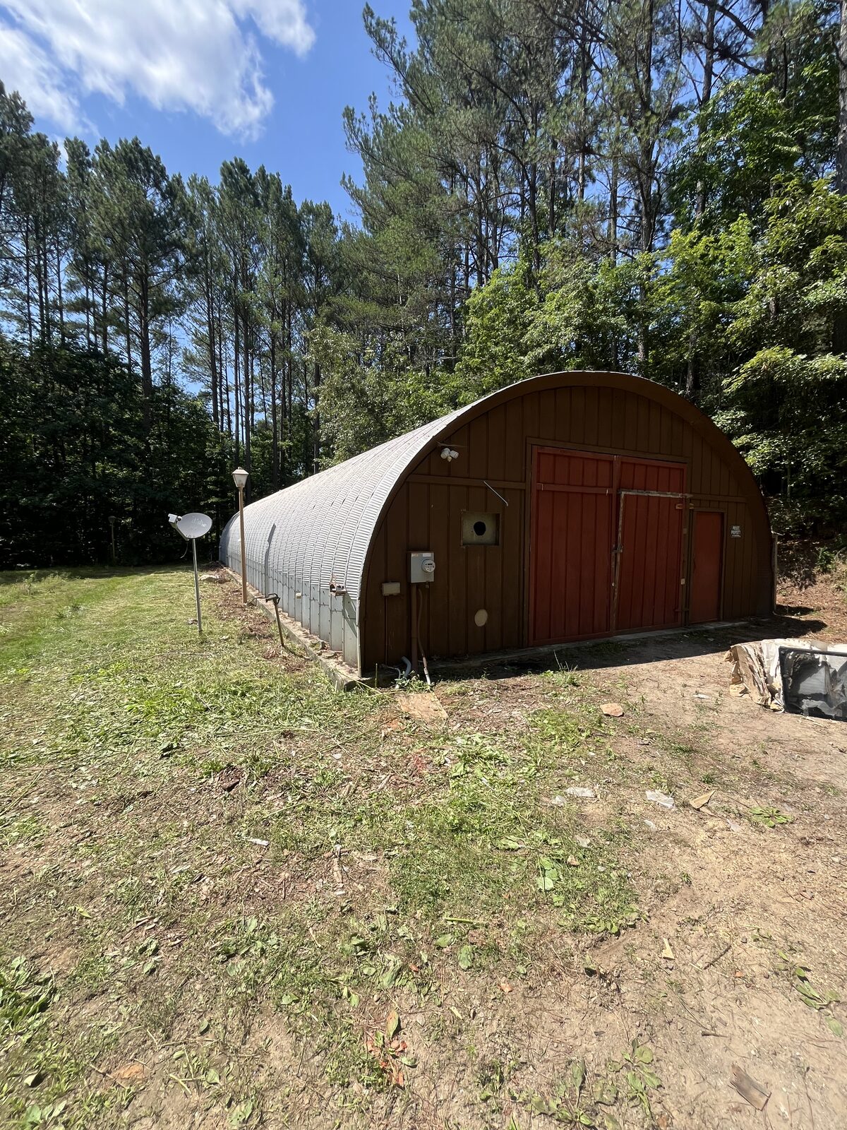 Grass and brush cut back to clean open ground around the building